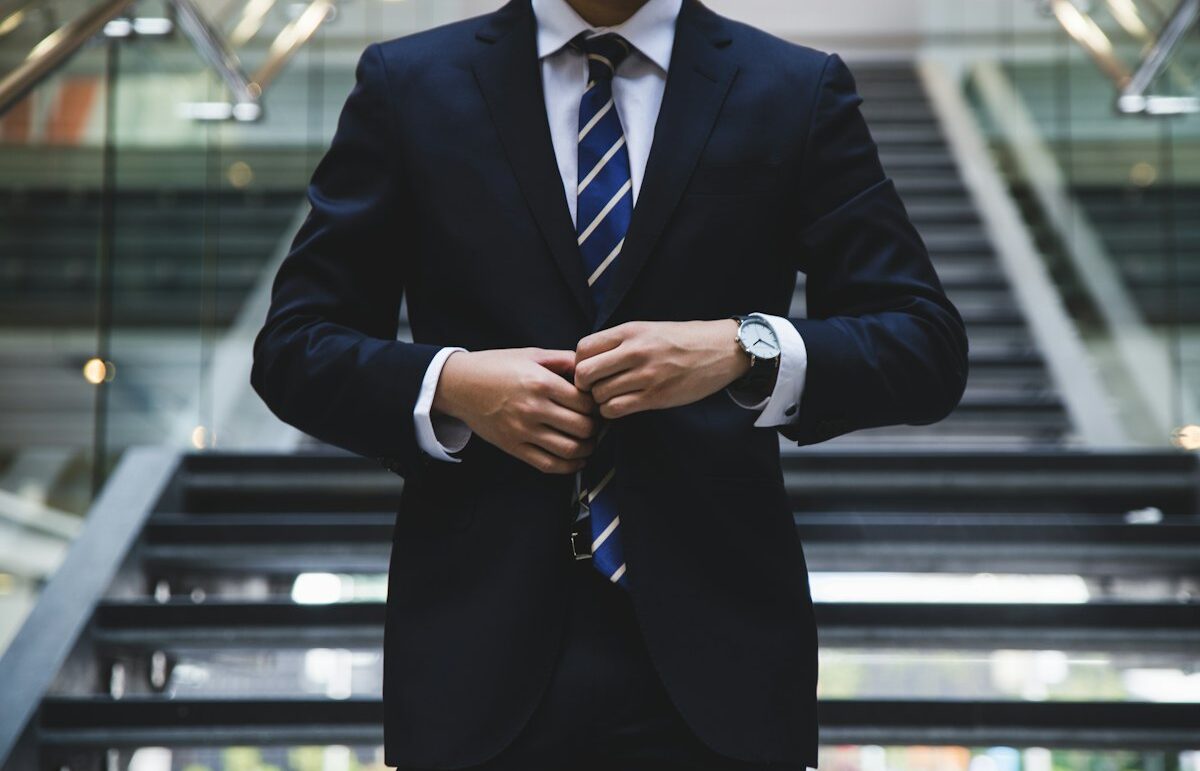 Person in a suit adjusting a cuff