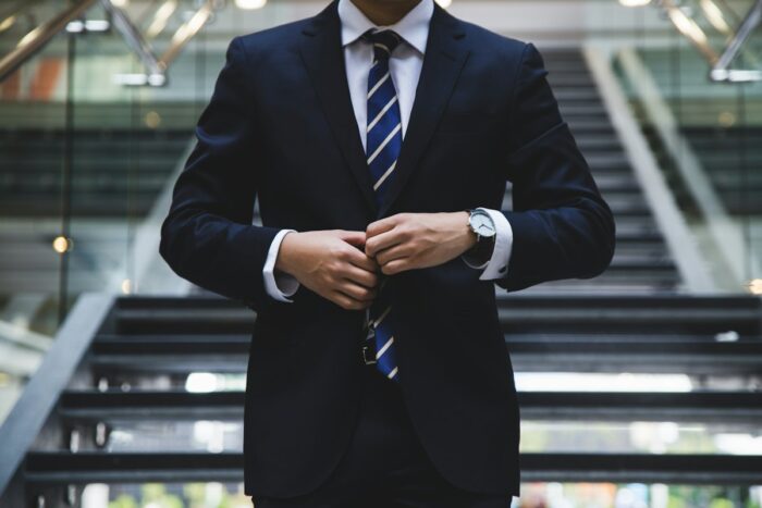 Person in a suit adjusting a cuff